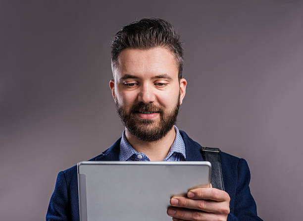 istock Hipster businessman with tablet, studio shot, gray background 522868758