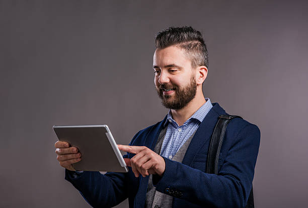 istock Hipster businessman with tablet, studio shot, gray background 522868946