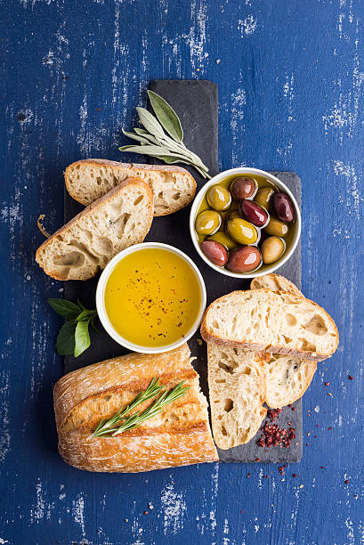 istock Mediterranean snacks set. Olives, oil, herbs and sliced ciabatta bread 522869430