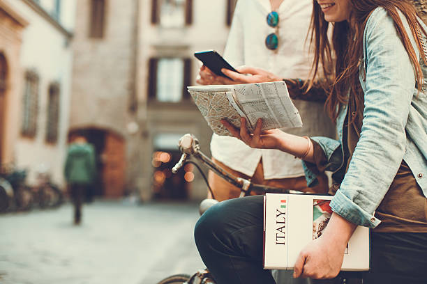 Tourists with guide and map in alleys of Italy Tourists with guide and map in alleys of Italy. They sit on a bike in the small streets of Firenze. bologna photos stock pictures, royalty-free photos & images