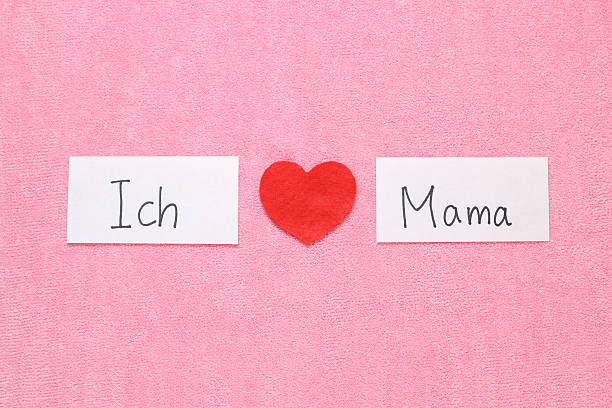 Red heart and hand written letters spelling I Love mom thank you concept in  German.