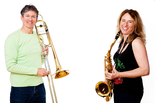 portrait of a mature man with a trombone and a woman with a tenor saxophone, isolated on white