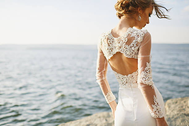 amanti in un abito da sposa vicino al mare e sulle montagne - wedding beach bride groom foto e immagini stock