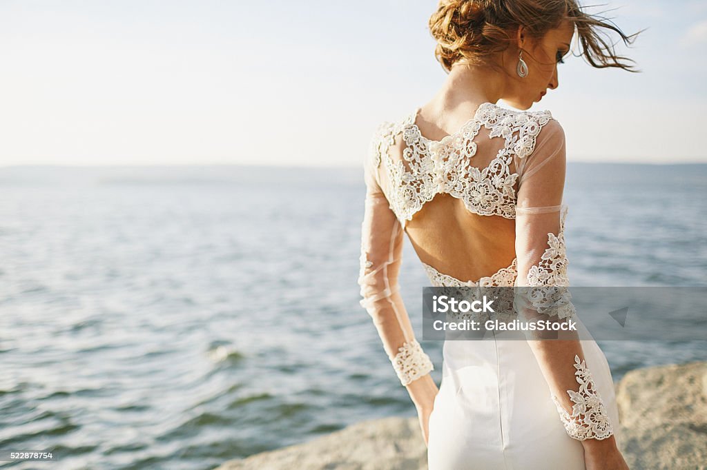 lovers in a wedding dress near the sea and mountains Wedding Dress Stock Photo