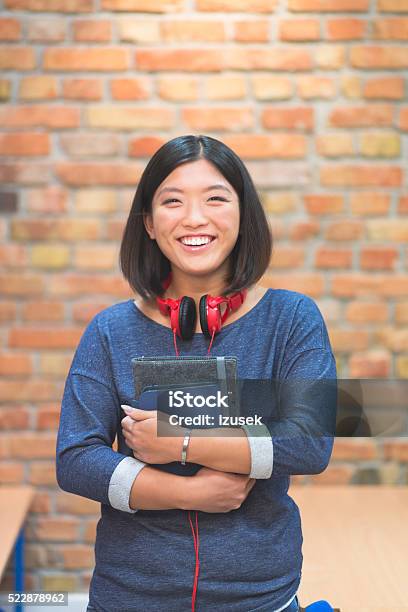 Happy Asian Student At School Stock Photo - Download Image Now - Adult, Asian and Indian Ethnicities, Brick Wall