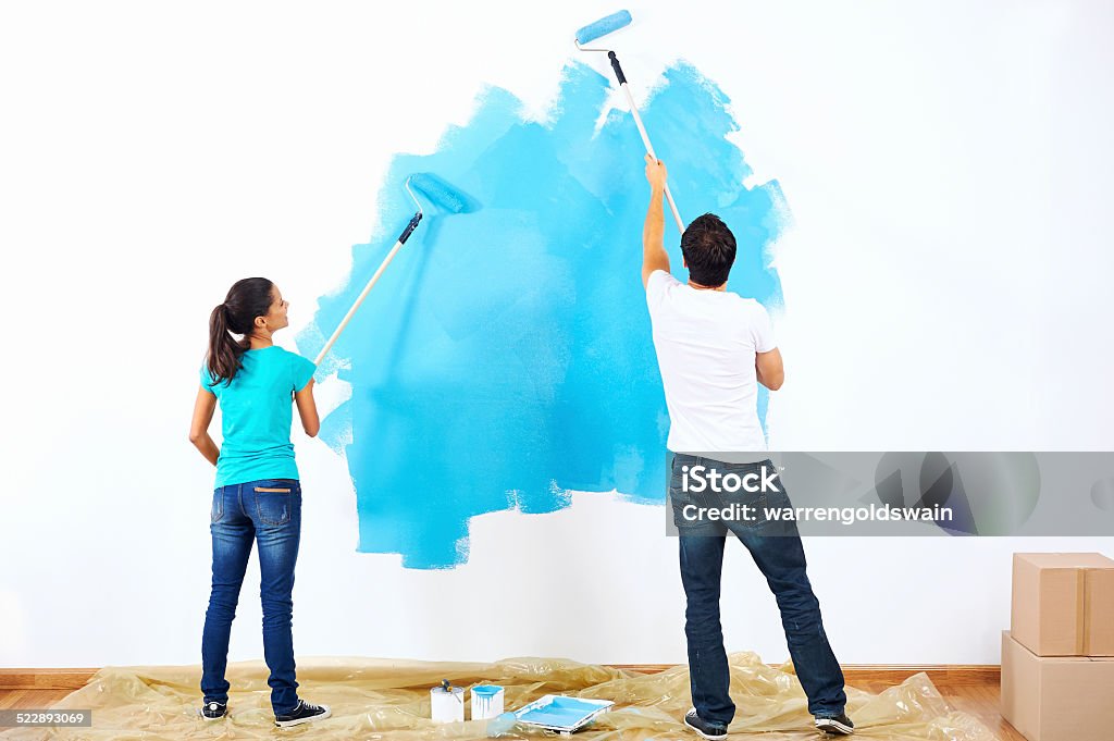 painting couple couple painting new home together with blue color happy and carefree relationship Painting - Activity Stock Photo