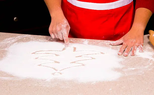 Photo of woman drawing into flour