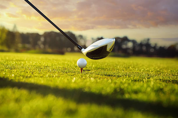 Golf club and ball in grass Golf ball on tee in front of driver drive ball sports photos stock pictures, royalty-free photos & images
