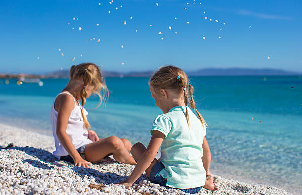 istock Adorable cute girls have fun on white beach during vacation 522895505