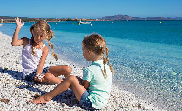 istock Adorable cute girls have fun on white beach during vacation 522895525