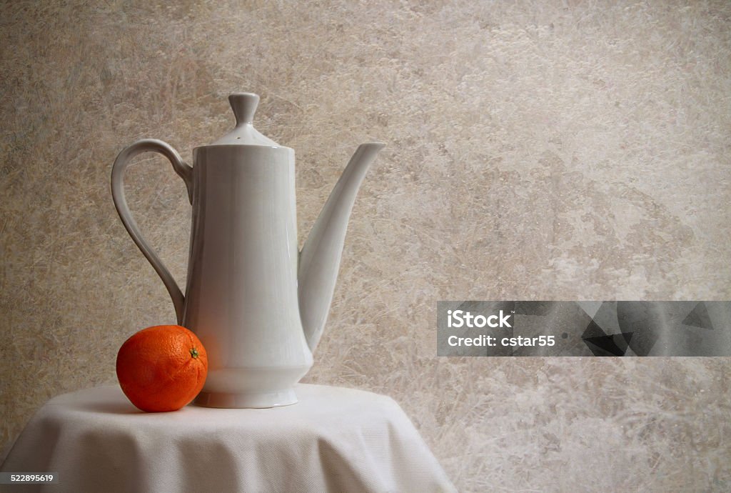 Fine Art Still Life of Teapot and Orange Fine Art photography still life of a teapot and orange with directional lighting Beige Stock Photo