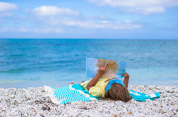 istock Adorable little girl with big map on tropical beach vacation 522896111