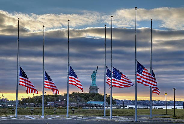 US flags at half staff and Statue of Liberty