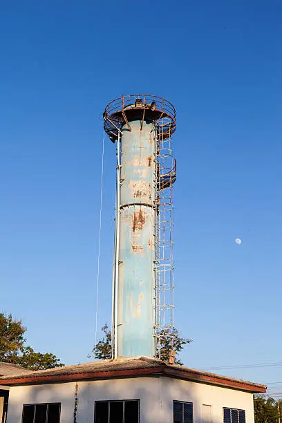 A blue watertower against a blue cloudy sky