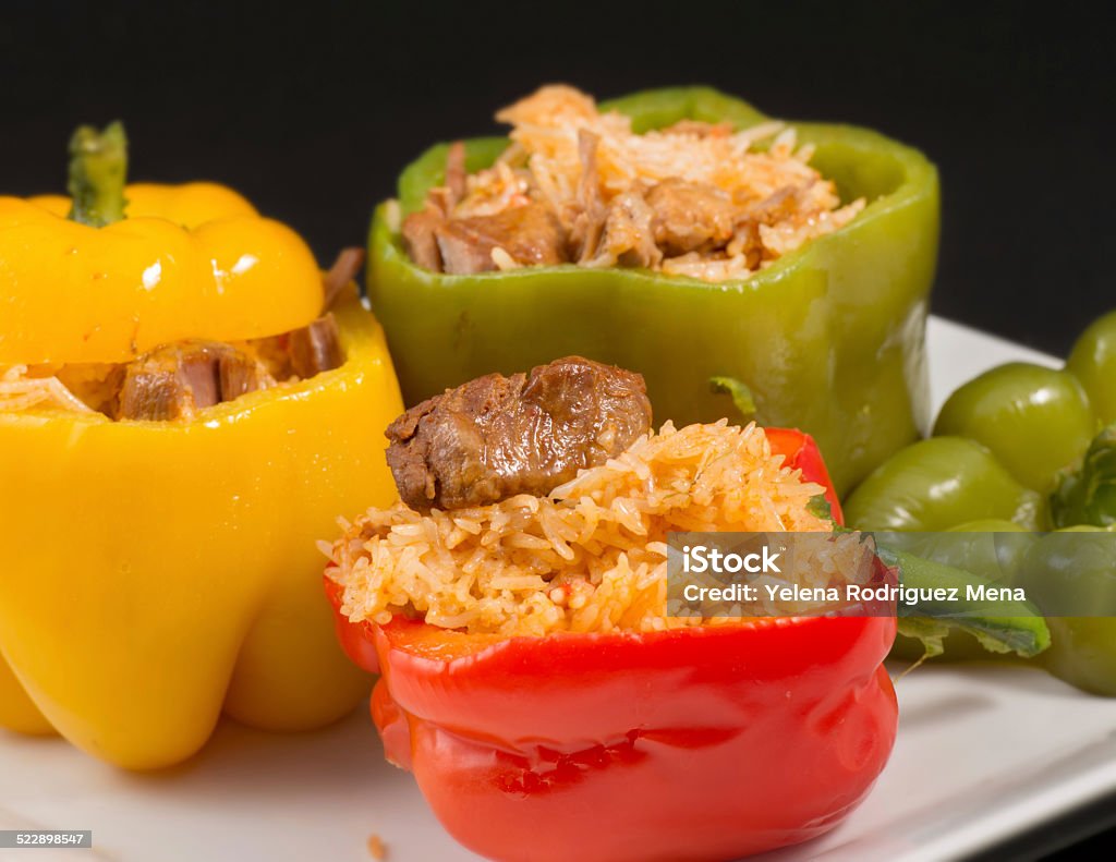 Cuban Cuisine: Bell Peppers Stuffed with Yellow Rice Cuban Cuisine: Bell Peppers Stuffed with Yellow Rice and pork meat. Creative presentation of a popular dish for dinner or lunch in the Caribbean Island American Culture Stock Photo