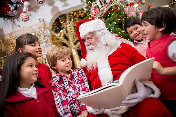 Santa reading to the children Santa reading a Christmas story to a group of children santa claus photos stock pictures, royalty-free photos & images