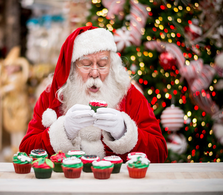 Very happy Santa eating a Christmas cupcake