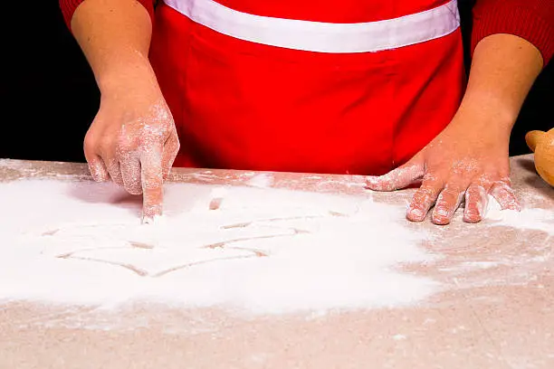 Photo of woman drawing into flour