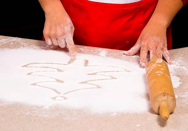 Photo of woman drawing into flour