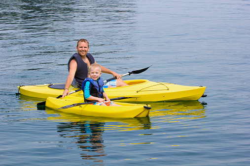 Family Kayaking together on a beautiful lake. Having fun on a family vacation