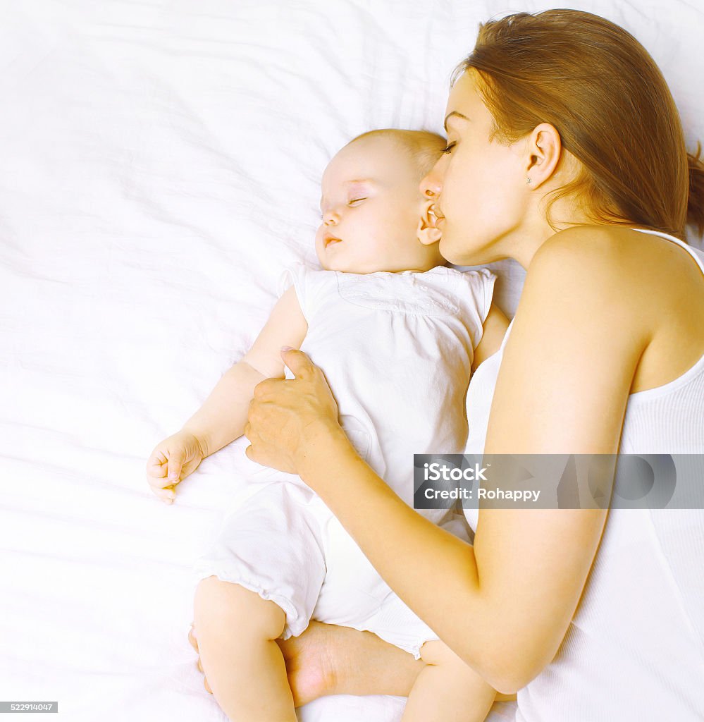 Mother together with baby sleeps in bed Baby - Human Age Stock Photo