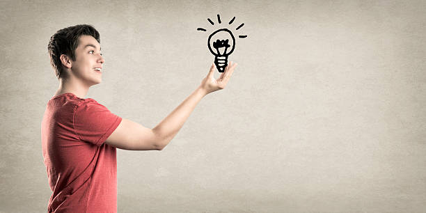 istock Happy Teenage Boy, reaching for a Light Bulb 522915093
