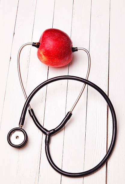 istock Medical stethoscope and red apple on a white table 522921707