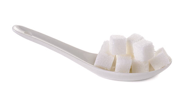 cube sugars in white spoon cube sugars in white spoon isolated on white background refined sugars stock pictures, royalty-free photos & images