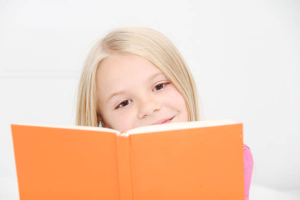 istock Cute little girl is reading book 522923179