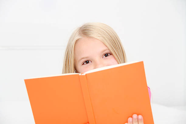 istock Cute little girl is reading book 522923217