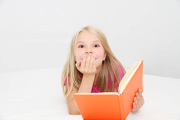 istock Cute little girl is reading book 522924163