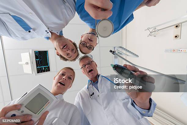 Doctors And Surgeon Checking On Patient Stock Photo - Download Image Now - Bed - Furniture, Blue, Care