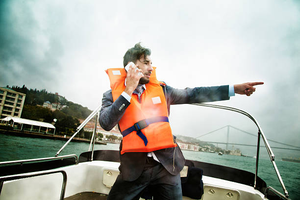 istock Businessman in nautical peril points towards salvation phone in hand 522926847