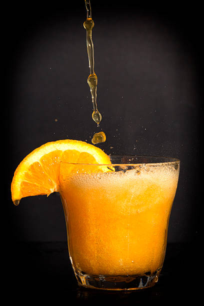 istock Orange flavoured soft drink splashing over the glass. 522927461