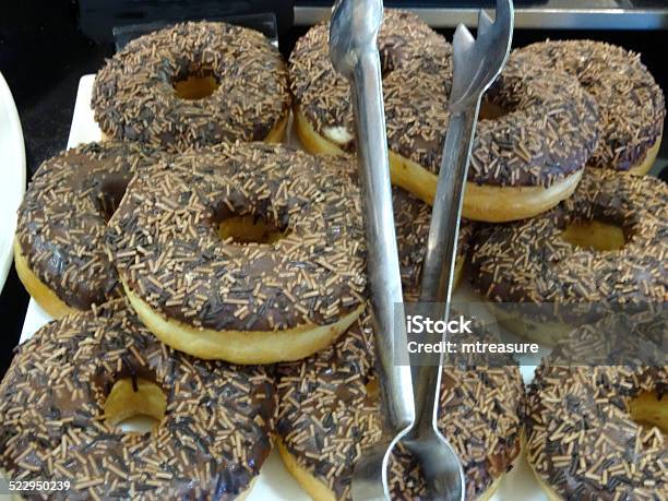 Image Of Freshly Cooked Ring Doughnuts With Chocolate Icing Sprinkles Stock Photo - Download Image Now