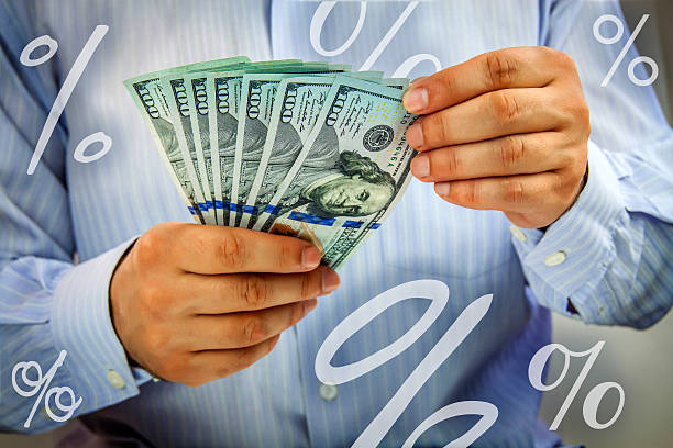 istock Hands counting money with percent signs floating around 522951867
