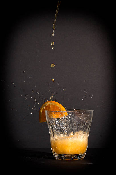 istock Orange flavoured soft drink splashing over the glass. 522960141