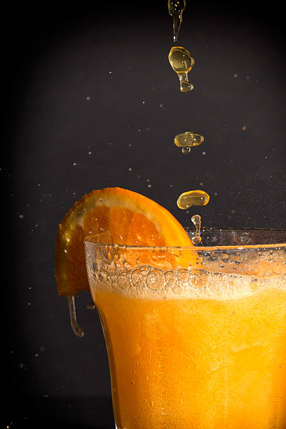 istock Orange flavoured soft drink splashing over the glass. 522960149
