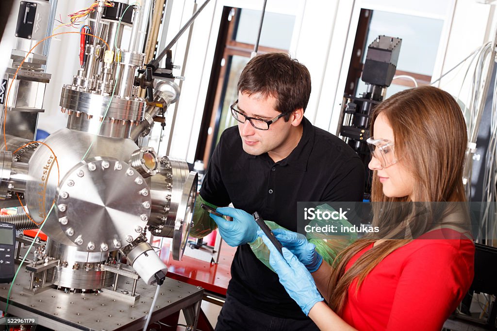 Os cientistas que trabalham com laser depósito câmara - Foto de stock de Física royalty-free