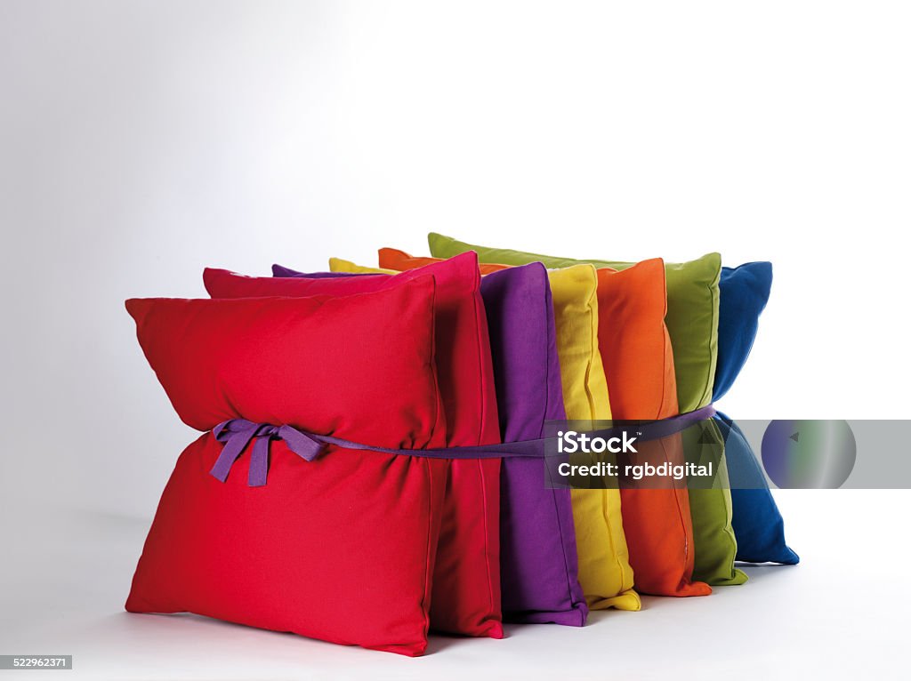 Cushions A group of colourful cushions tied together with purple ribbon on a lit grey background Colors Stock Photo