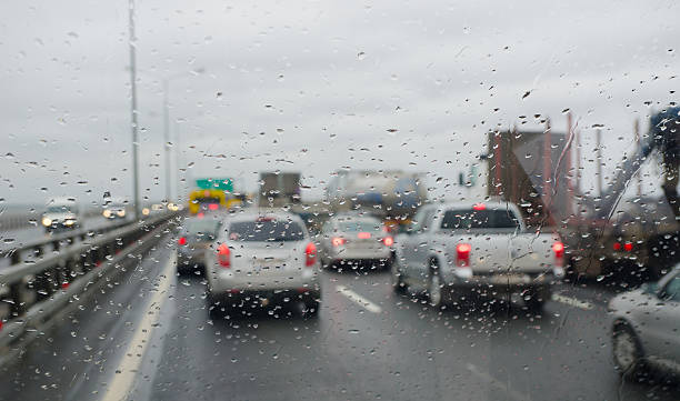 Defocussed traffic viewed through a car windscreen covered in rain
