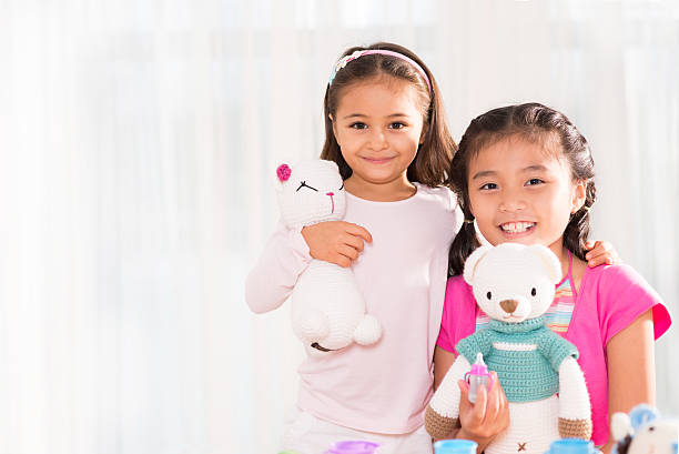 Little girl and baby boy, brother and sister playing in parents bed. Family with children in the morning. Kids play in white bedroom. Nursery crib bedding and textile for young child. Siblings love.
