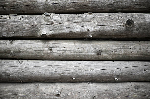 Old wooden house wall, gray logs with knots