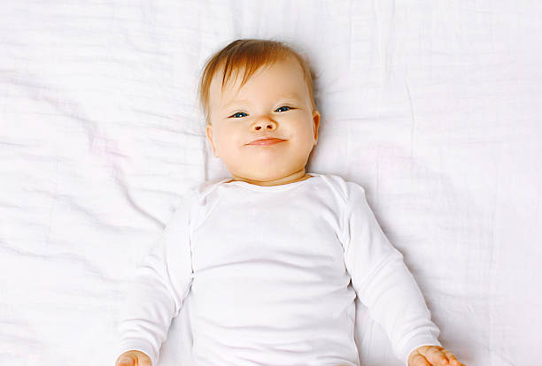istock Portrait positive baby lying on the bed, top view 522978575