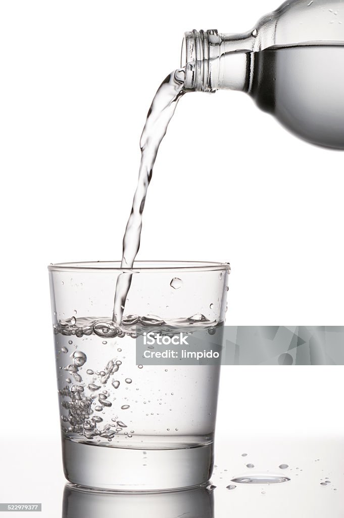 water glass pouring water into glass from a bottle, on white background Carbonated Water Stock Photo