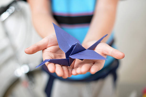 istock Origami crane in children's hands 522980999