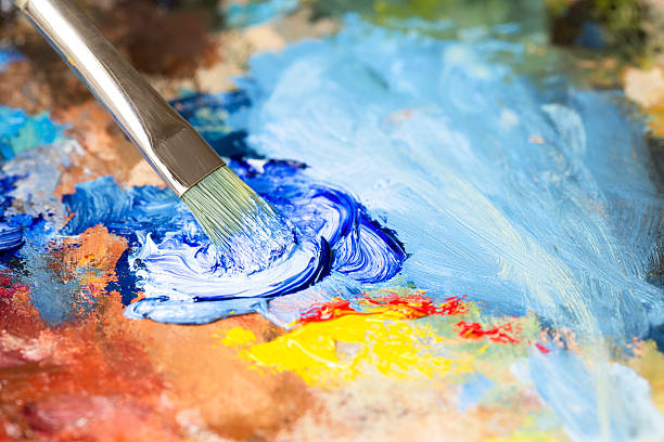 istock Paintbrush with blue oil paint on a classical palette 522983691