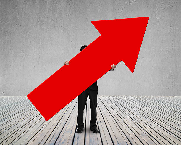 istock man holding red arrow up sign 523001703