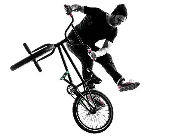 one  man exercising bmx acrobatic figure in silhouette studio isolated on white background