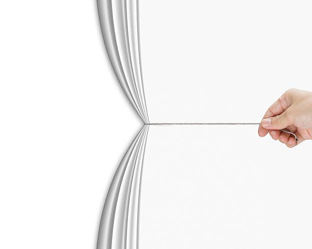 human hand pulling open white blank curtain with empty behind stock photo